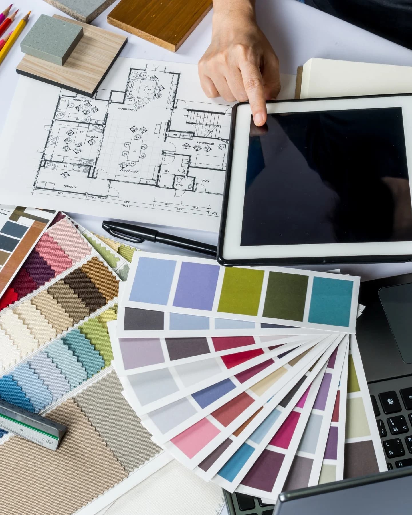 Floor plans, fabric swatches and colour charts on a designer's desk