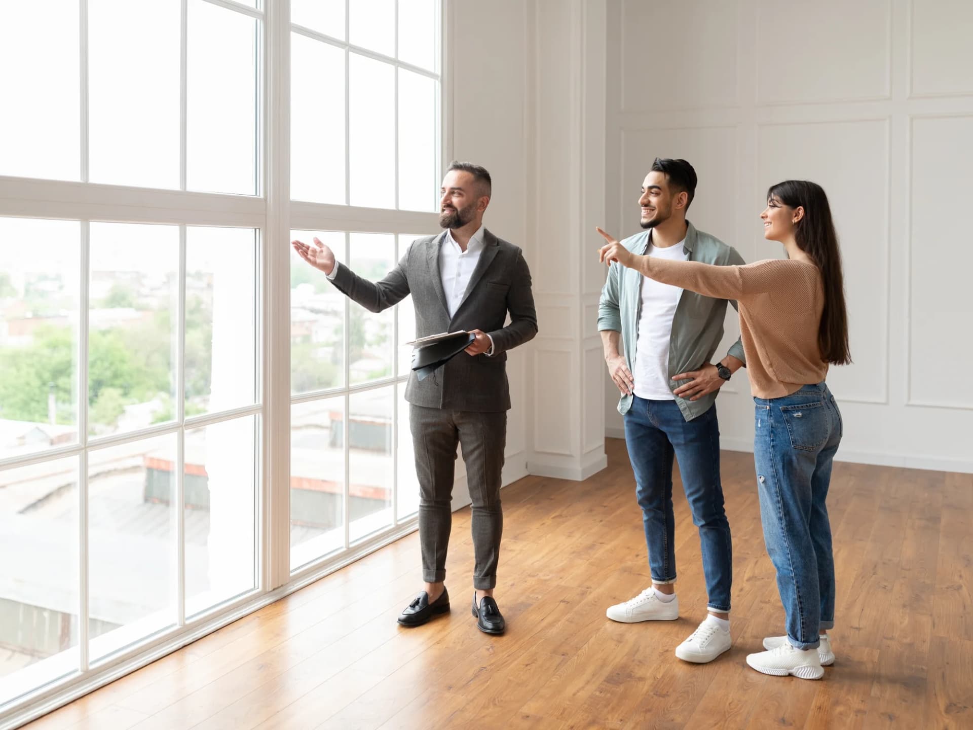 Agent showing a couple around an empty apartment