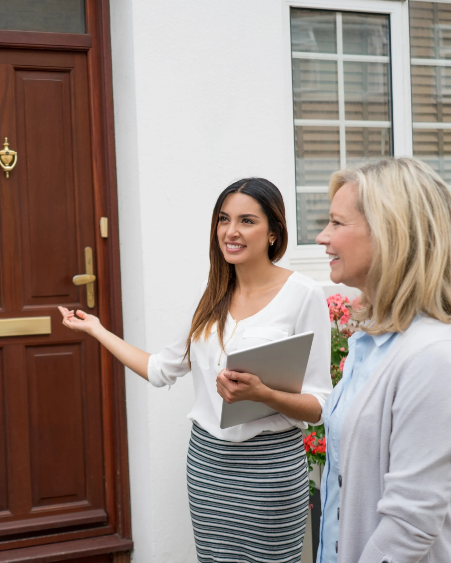 Agent welcoming buyers at the front door