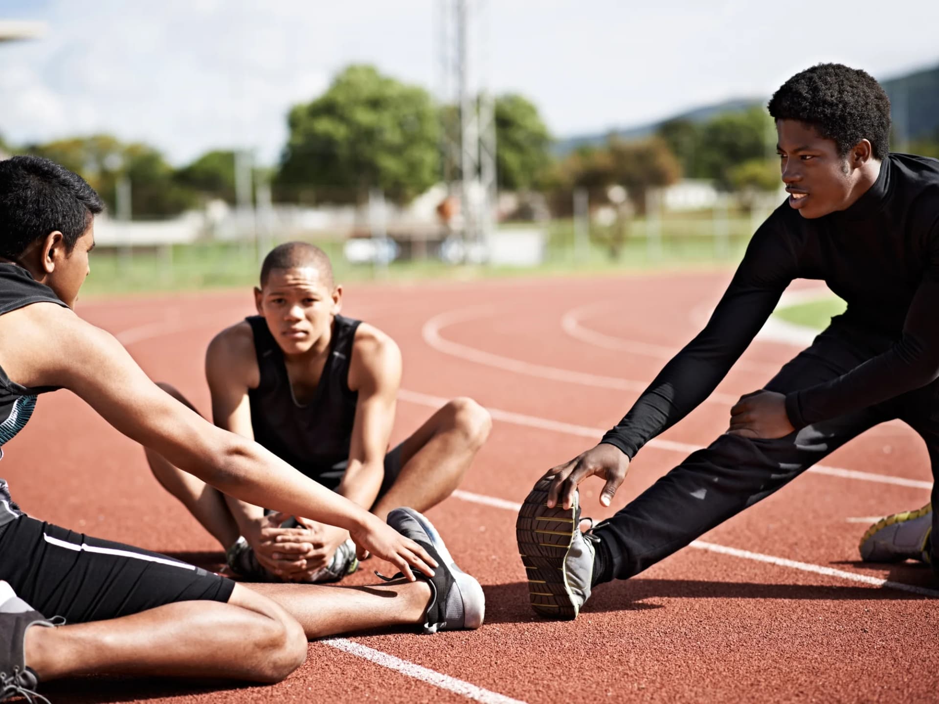 Athletes stretching on a running track