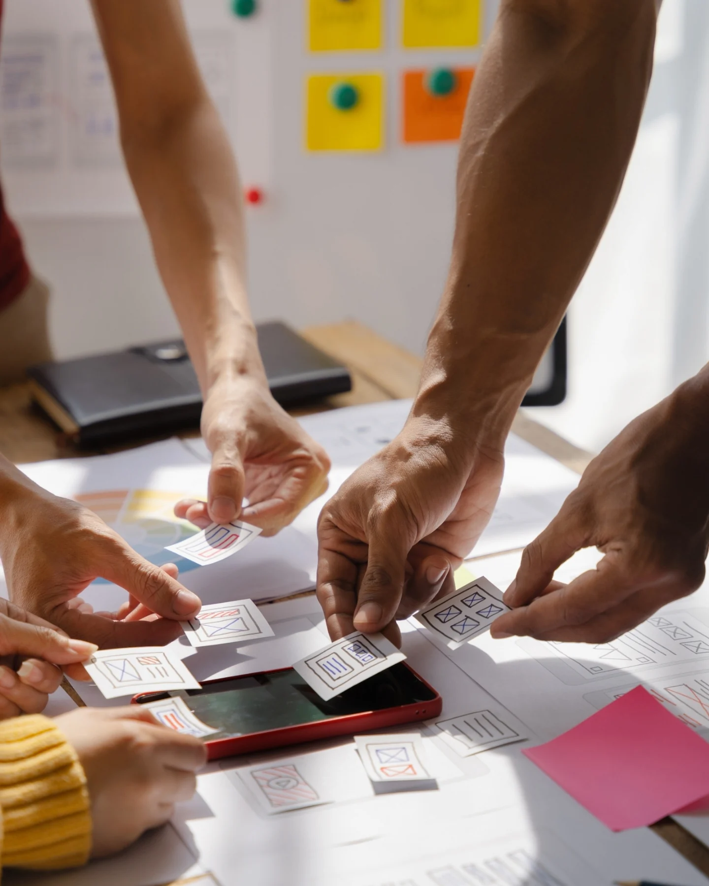 Hands arranging sticky notes during a planning session