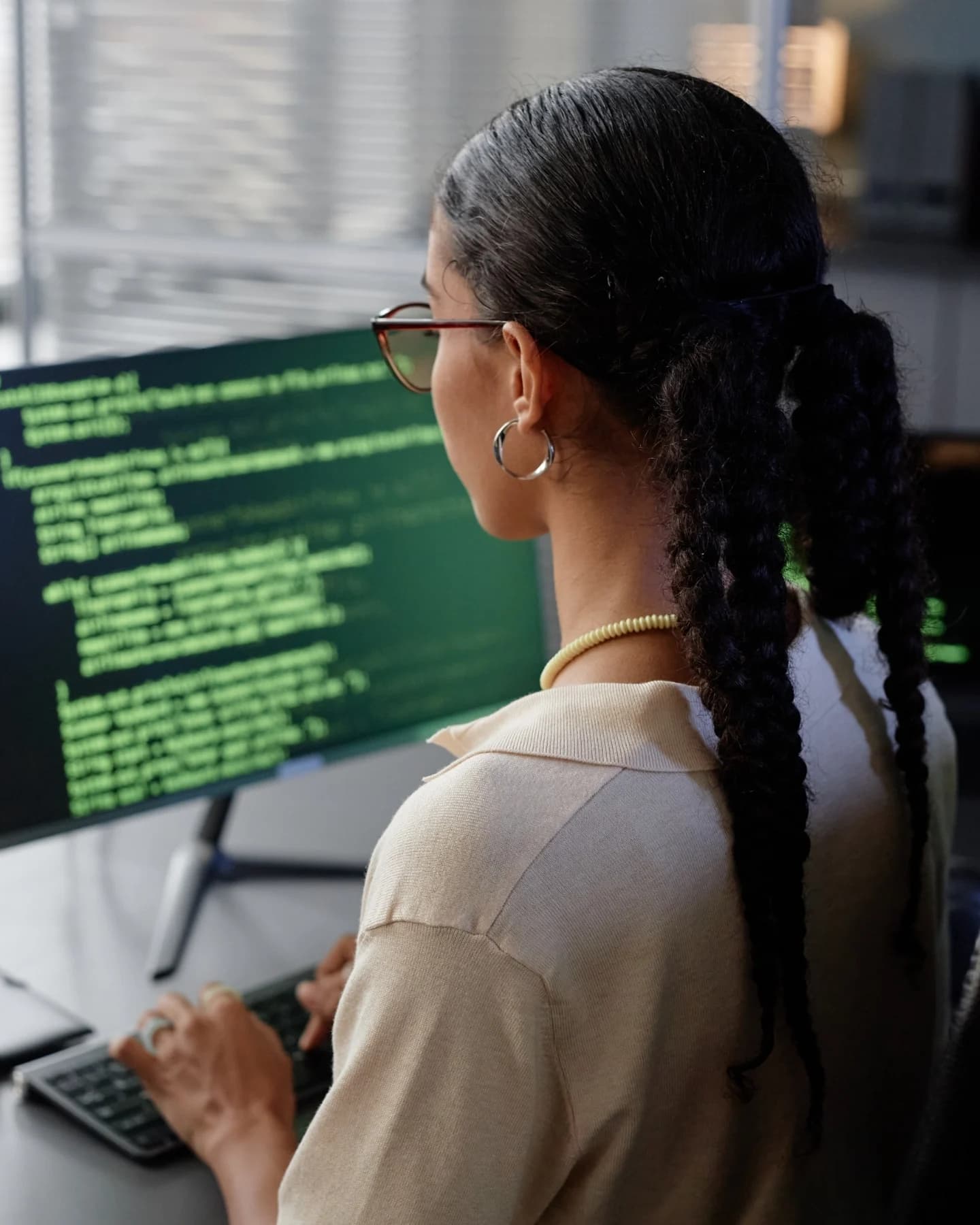 Engineer reviewing code on two monitors