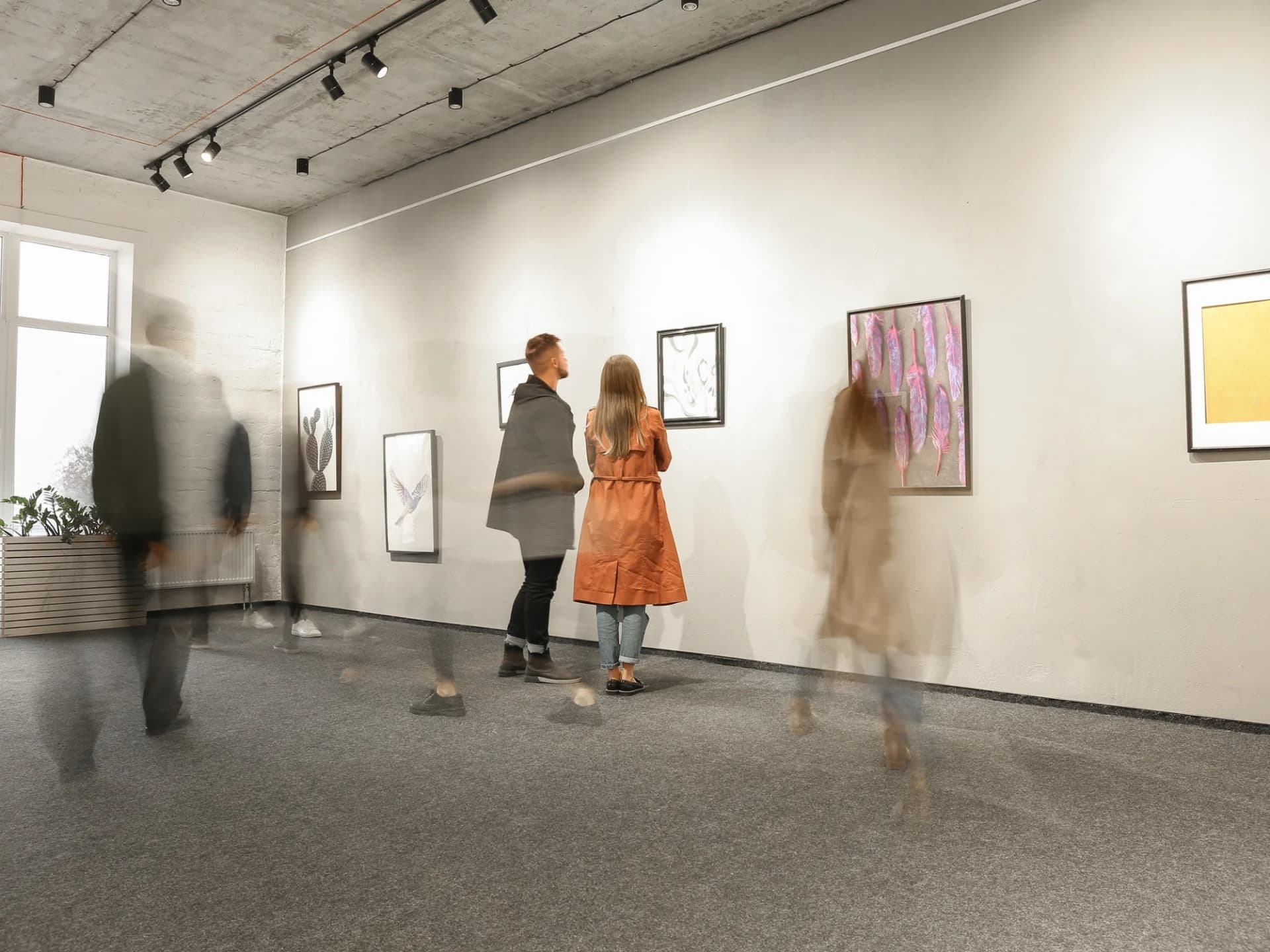 Visitors walking through a white-walled gallery