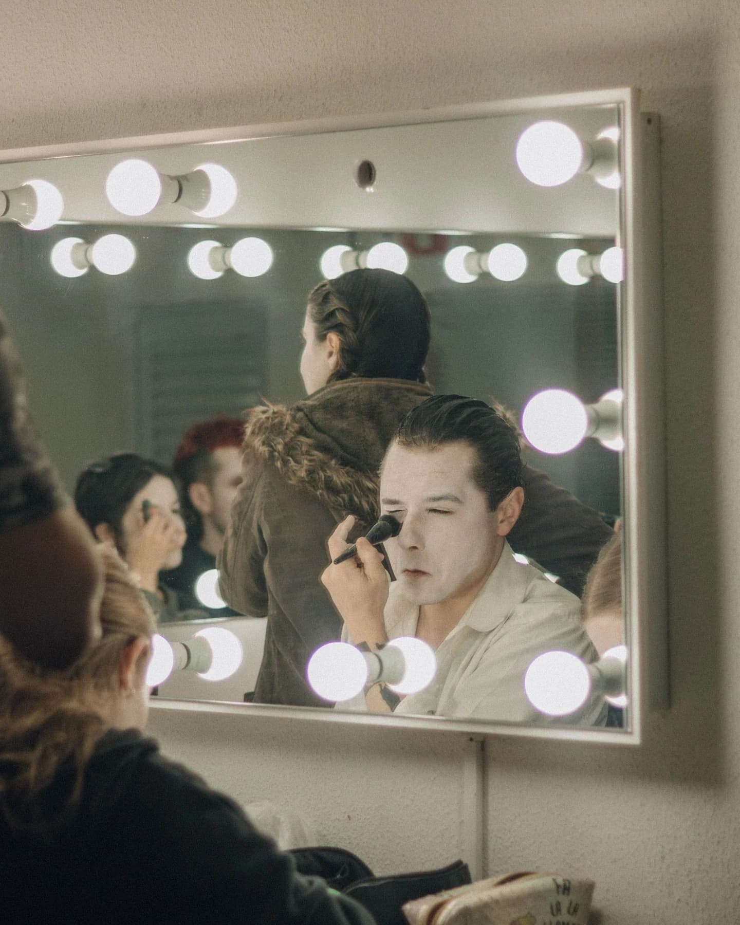 Performer getting ready at a dressing room mirror