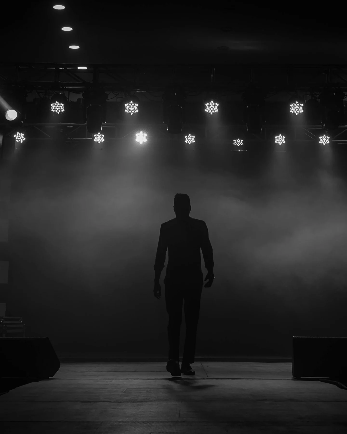 Performer walking onto a dark stage