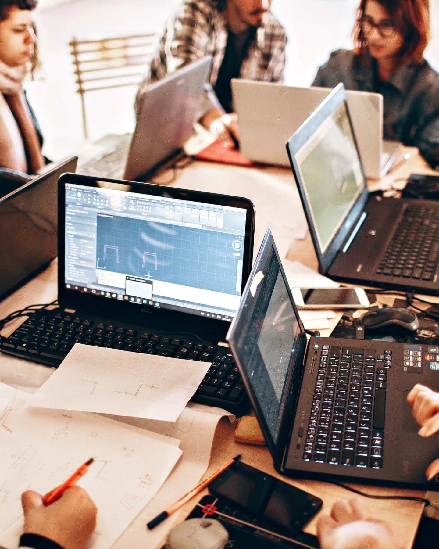 Laptops and notes on a shared desk, seen from above