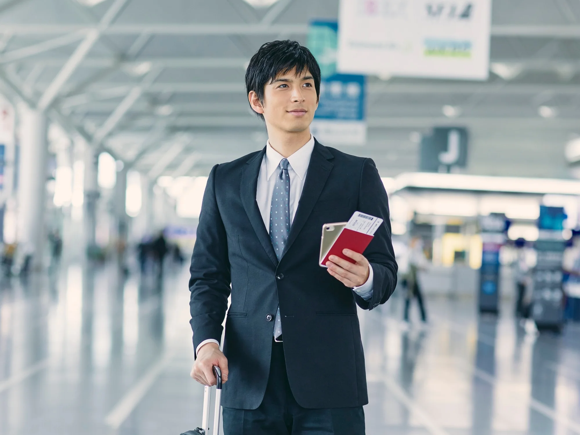 Business traveller holding a passport in an airport terminal