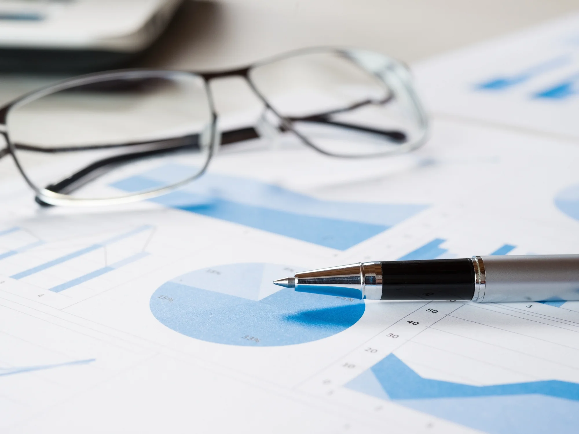 Glasses and a pen on a fund performance report
