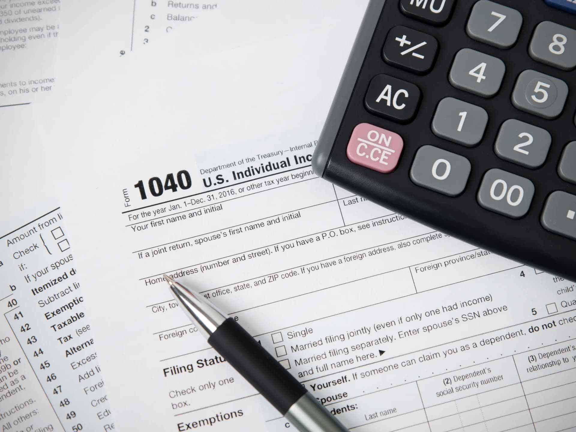US Form 1040 with a pen and calculator